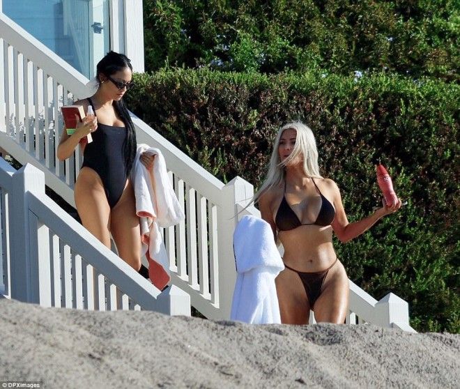 Back to the beach The reality guru who is releasing a new fragrance held into a bottle as her pal carried a book